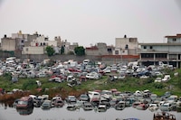 Vecinos de Tecámac y Ecatepec, en alerta por olores químicos por autos bajo el agua y tiradero de basura