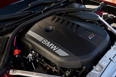 Detalle del motor del BMW M350 xDrive, tapa negra con logotipo BMW y emblema M