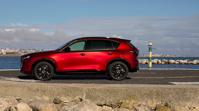 Mazda CX-5 2026 rojo visto de perfil con diseño Kodo y carrocería de mayor tamaño.
