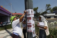Familias de personas desaparecidas pegan fichas de búsqueda en el Estadio CDMX