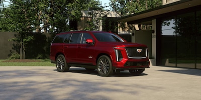 Cadillac Escalade V 2026 color rojo vista tres cuartos delantera SUV de lujo deportivo con motor V8 682 hp badge V-Series y rines negros deportivos.