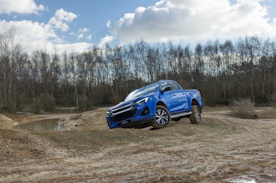 Isuzu D-MAX 2027 azul en ángulo pronunciado sobre terreno de tierra durante prueba off-road