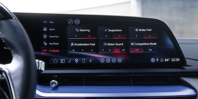 Pantalla central Cadillac Optiq V 2026 con modos de manejo V-Mode activado en rojo ajustes de suspensión dirección frenado y motor SUV eléctrico deportivo gama V-Series