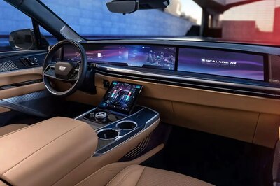 Interior del Cadillac Escalade IQ 2026 mostrando pantalla panorámica curva con sistema de infoentretenimiento, cuadro de instrumentos digital, consola central con pantalla táctil y tapicería en cuero beige con iluminación ambiental