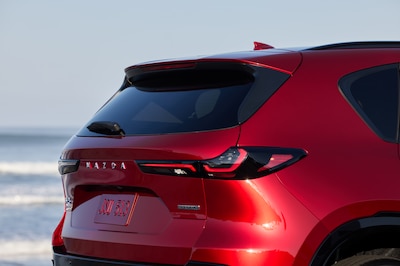 Mazda CX-5 2025 color rojo Soul Red vista trasera tres cuartos estacionado en playa con mar de fondo SUV compacto con motor SkyActiv-G 2.5 litros 177 hp y rines negros deportivos