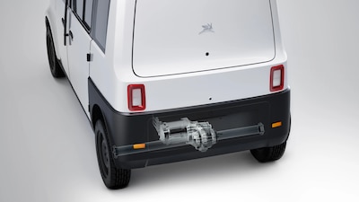 Vista trasera del Olinia Uno color blanco con corte transparente mostrando el motor eléctrico de 13 kW, luces traseras rojas y logo de animal alado, chasís tubular auto urbano mexicano
